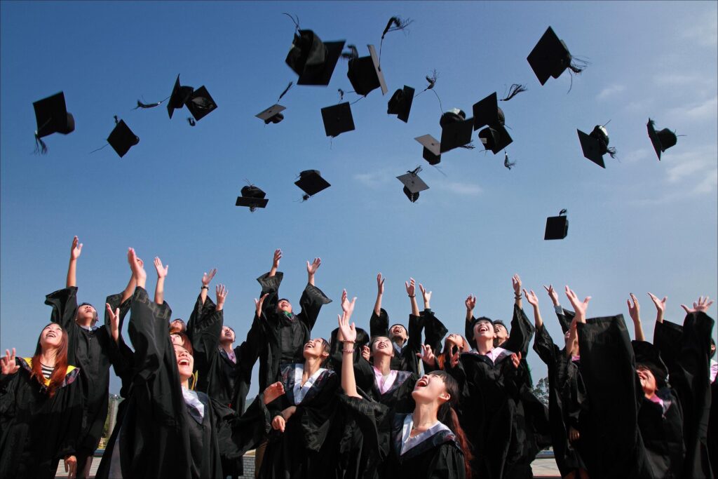 University graduates throwing their graduation caps into the air.
